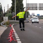 Un agente de la Guardia Civil de Tráfico da el alto a un conductor en un control