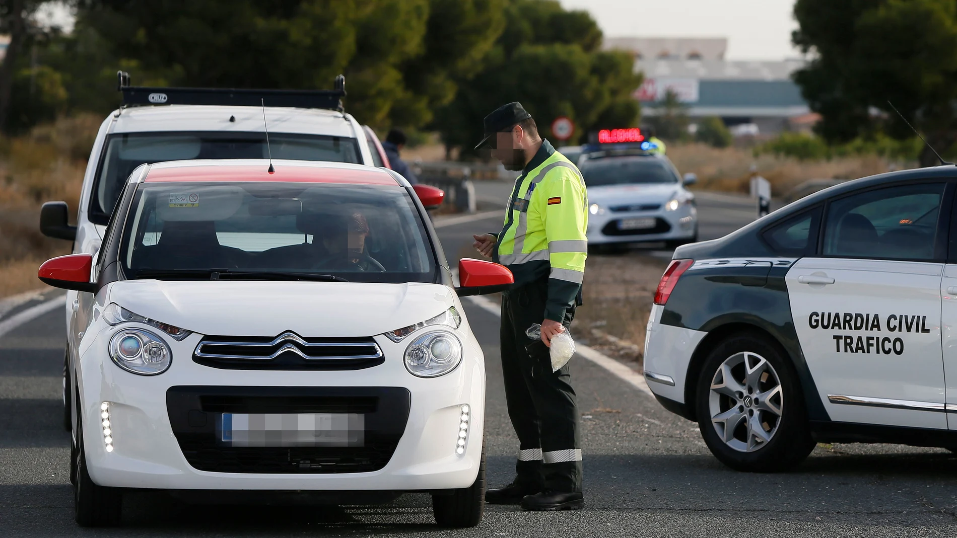 Un agente de la Guardia Civil da el alto a un vehículo en un control de tráfico