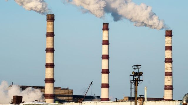 fábrica con chimeneas echando humo