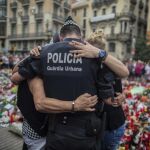 Un agente y dos barceloneses se funden en un abrazo tras los atentados de Barcelona
