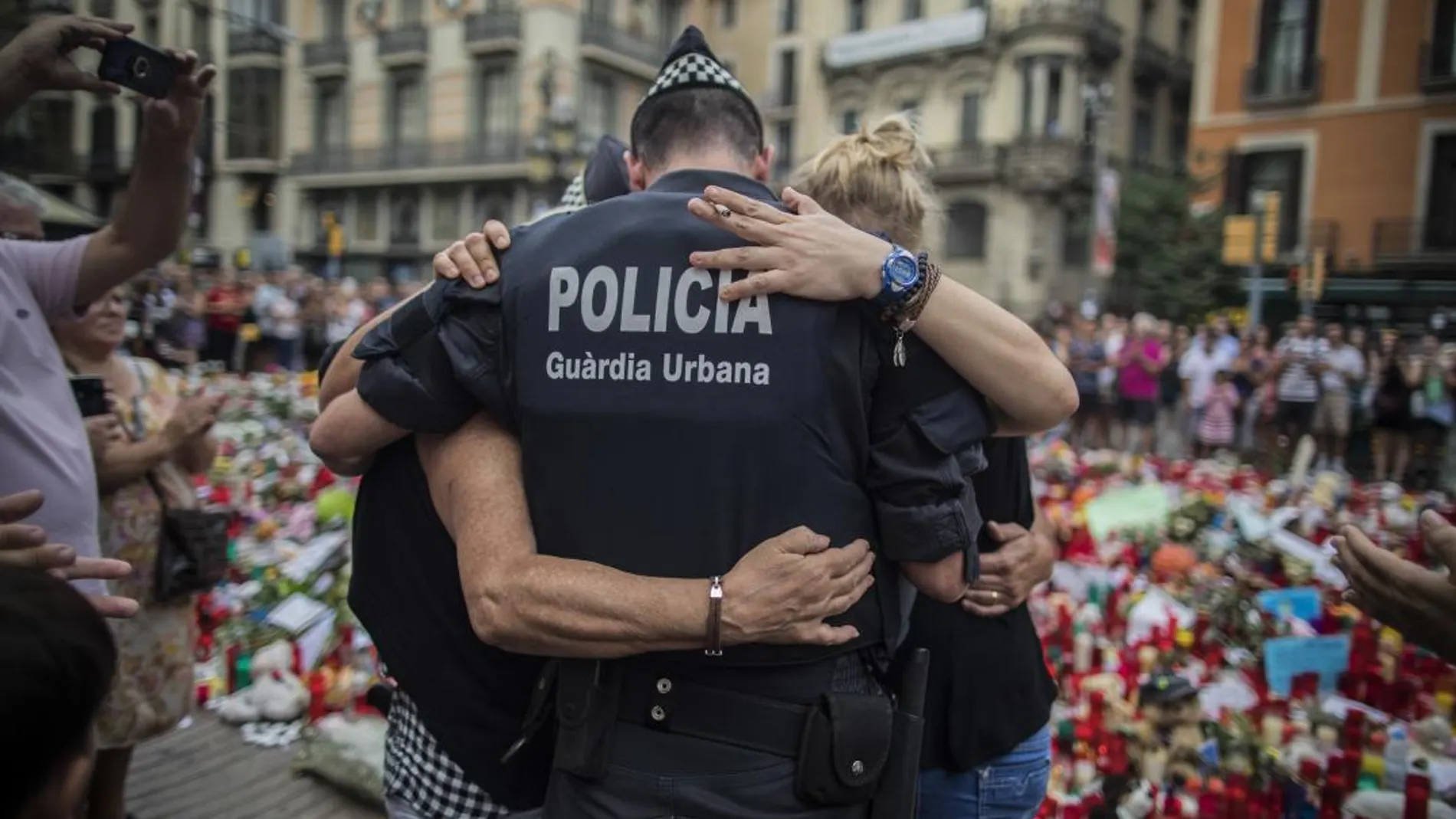 Un agente y dos barceloneses se funden en un abrazo tras los atentados de Barcelona