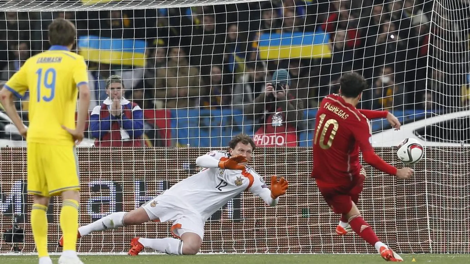 El centrocampista español Césc Fábregas (R) marca el penalti ante el portero ucraniano Andriy Pyatov (c) durante el partido