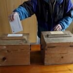 Un hombre suizo vota en un referéndum sobre una iniciativa que pretende establecer la expulsión automática de los extranjeros que hayan cometido delitos graves en Bauen, Suiza, hoy domingo 28 de noviembre de 2010