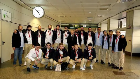 El seleccionador español de balonmano Manolo Cadenas (2d) y el presidente de la Real Federación Española de Balonmano, Francisco Blázquez García (c), entre otros, posan con el equipo a su llegada hoy al aeropuerto de Barajas