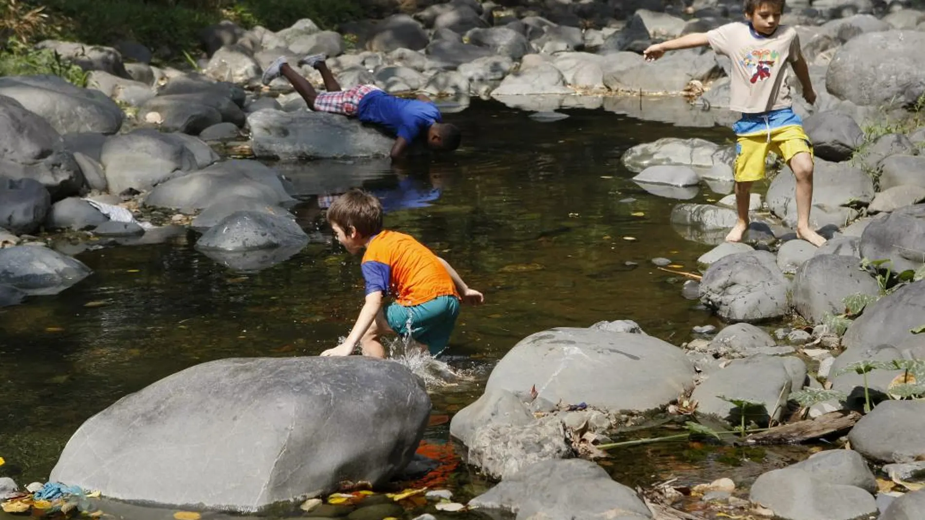 Un grupo de niños juega este sábado en el río Cali de la ciudad de Cali (Colombia). El IDEAM (Instituto de Hidrología, Meteorología y Estudios Ambientales de Colombia) alertó sobre un déficit de lluvias entre el 40% y el 60% en la región del Valle del Cauca para la temporada