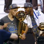 Stephen Curry sostiene el trofeo junto a Andre Iguodala, que también ganó el premio de Jugador Más Valioso (MVP)
