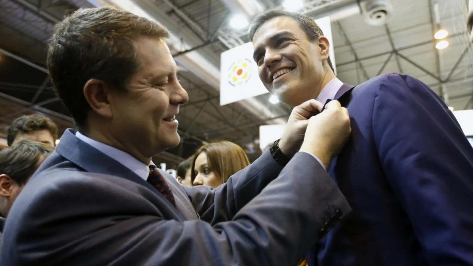 Emiliano García-Page le pone una insignia al secretario general del PSOE, Pedro Sánchez en Fitur.