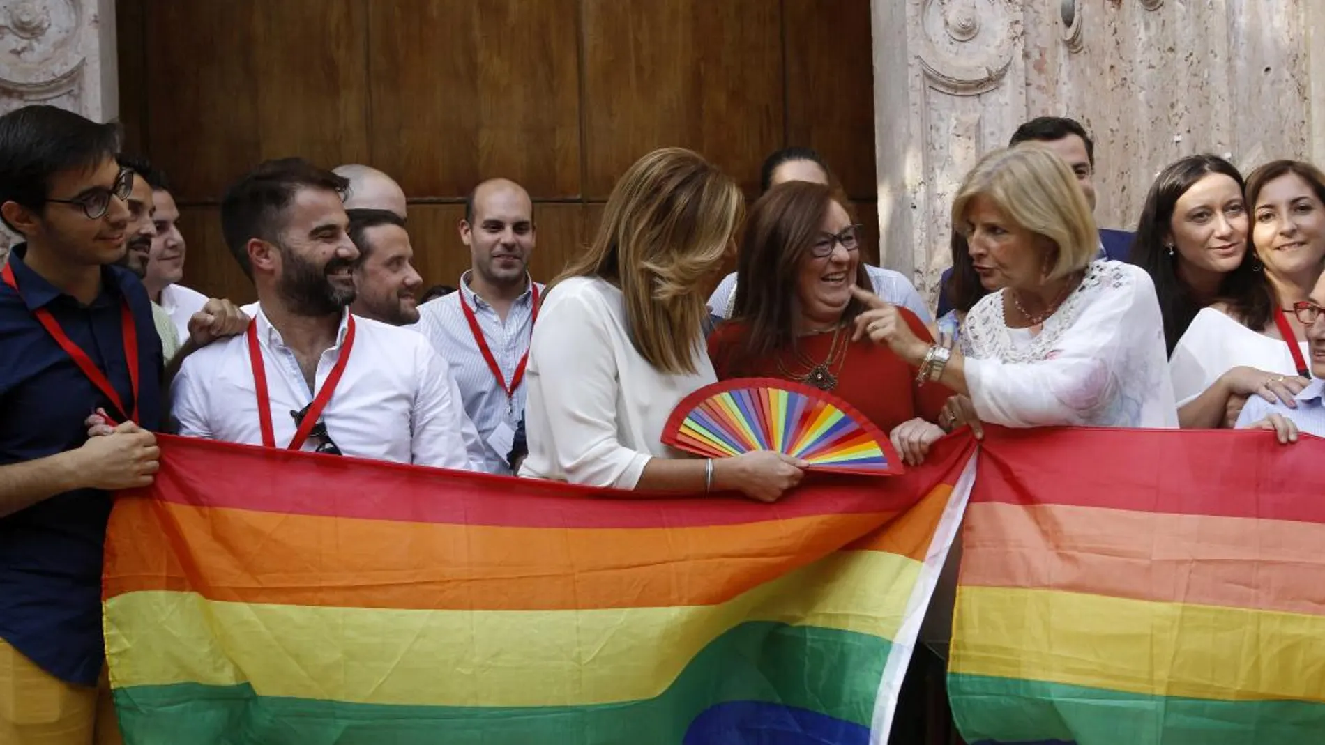 La presidenta de la Junta (c), diputados y miembros de asociaciones LGTBI posan con la bandera arcoiris en el Parlamento