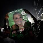 Seguidores sostienen carteles electorales de la candidata presidencial Mirlande Manigat