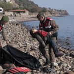 Un policía turco recoge el cuerpo sin vida de un niño tras el naufragio