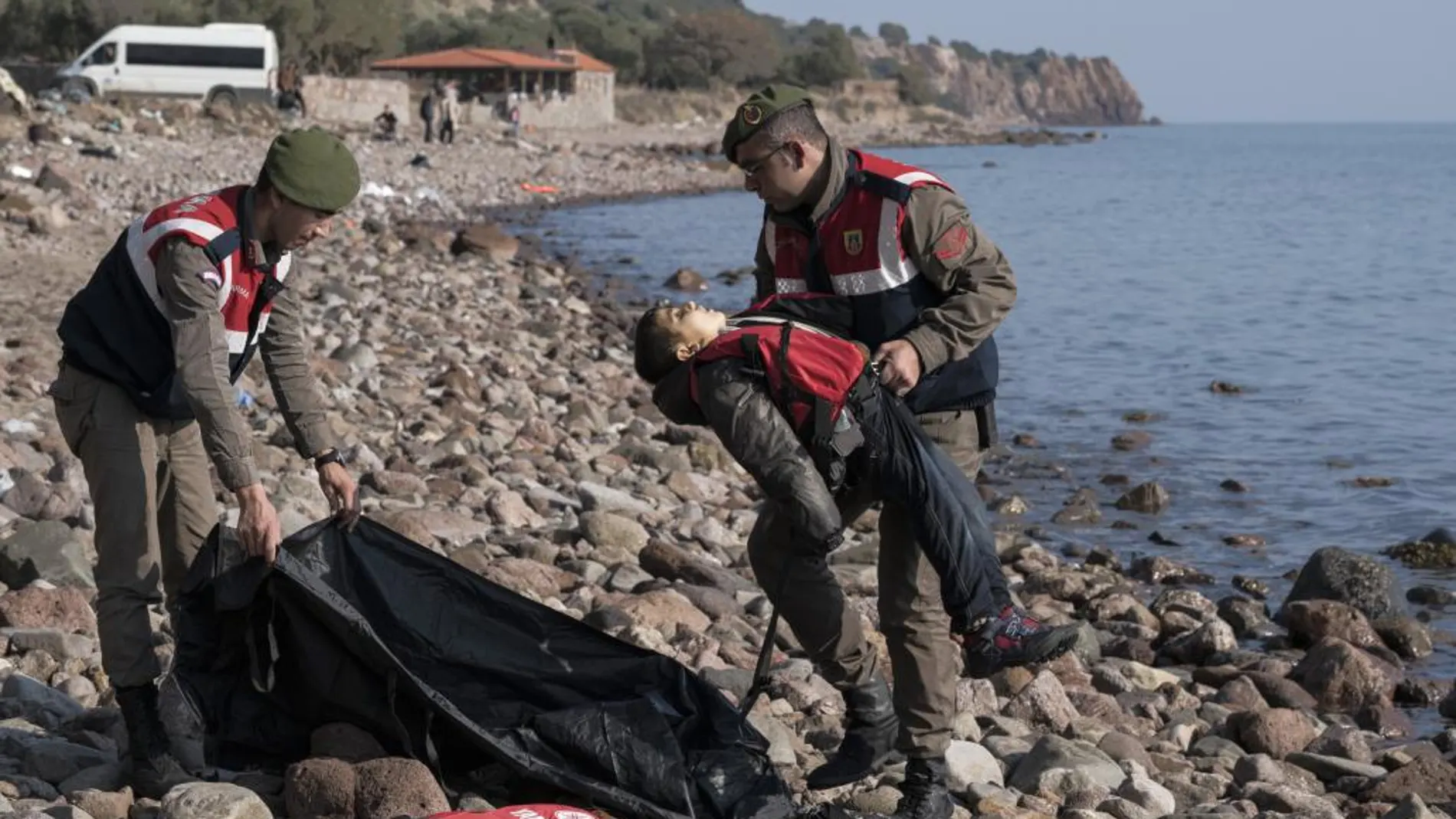 Un policía turco recoge el cuerpo sin vida de un niño tras el naufragio
