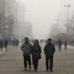 Peatones utilizan máscaras protectoras en Pekín (China) el 30 de noviembre de 2015. La capital china amaneció envuelta en una densa capa de contaminación que mantiene a la metrópolis en alerta naranja