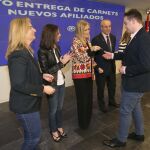 La presidenta de la gestora del PP de Madrid, Cristina Cifuentes, entrega su nuevo carnet al afiliado más joven