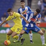 El centrocampista del Villarreal Denis Suarez (i) con el balón ante el defensa del Espanyol Javier López Rodríguez.