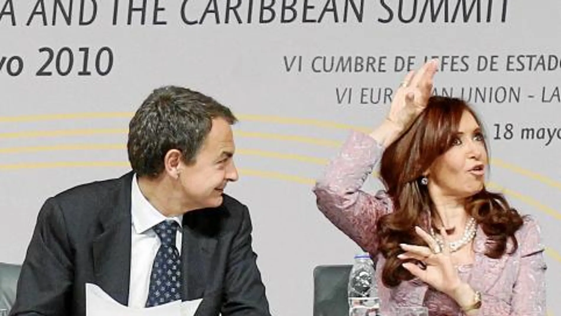 Zapatero observa sorprendido la gesticulación de la presidenta argentina, ayer, en el plenario de la cumbre
