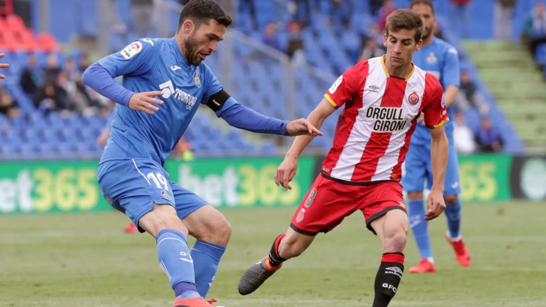 El centrocampista del Girona, Pere Pons (d), trata de robar el balón al delantero del Getafe, Jorge Molina (i), durante el partido. Efe