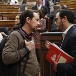 El secretario general de Podemos, Pablo Iglesias, conversa con el líder de IU, Alberto Garzón, tras la primera sesión del primer día de debate de totalidad al proyecto de Ley de Presupuestos Generales del Estado de 2018