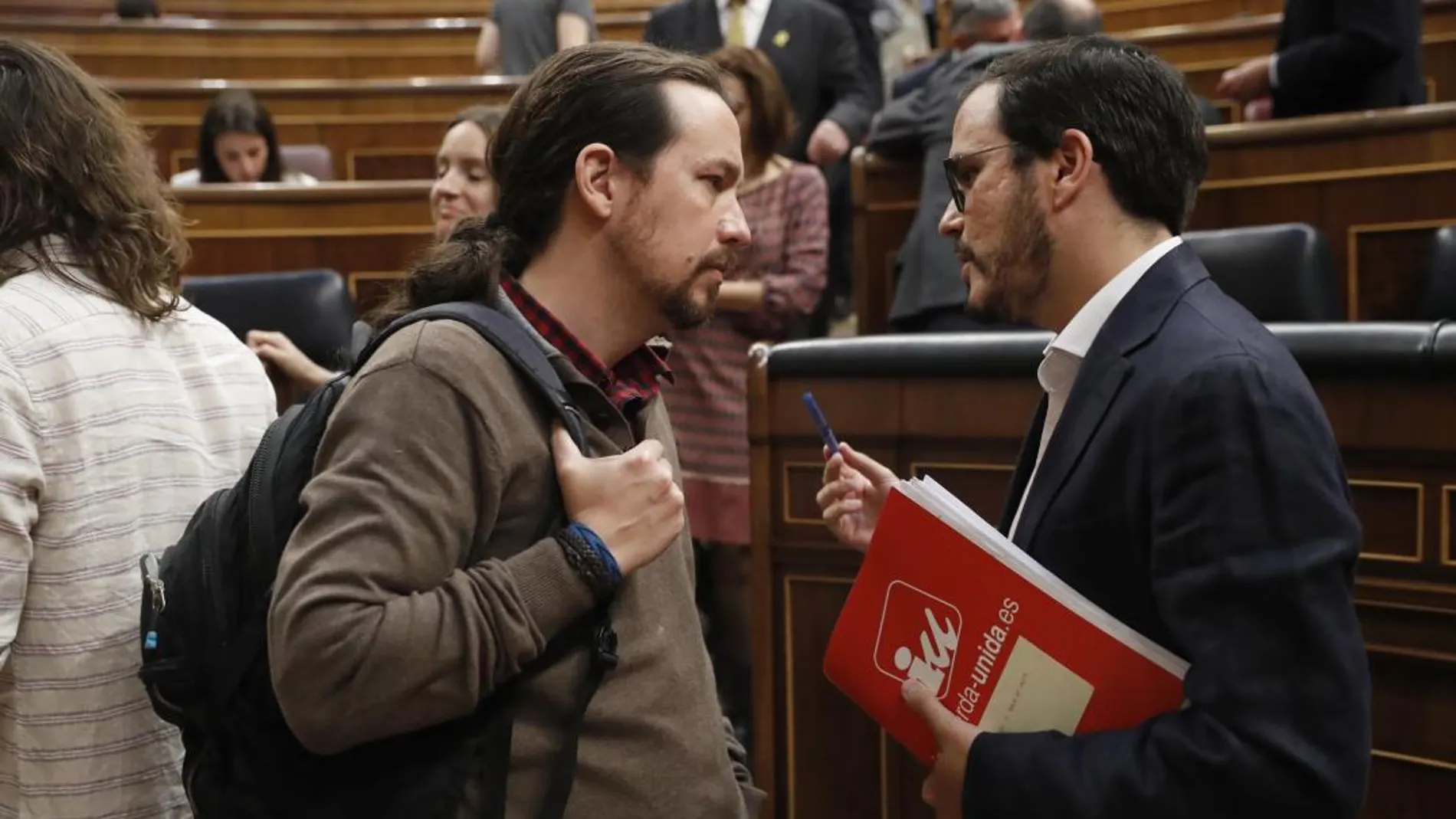 El secretario general de Podemos, Pablo Iglesias, conversa con el líder de IU, Alberto Garzón, tras la primera sesión del primer día de debate de totalidad al proyecto de Ley de Presupuestos Generales del Estado de 2018