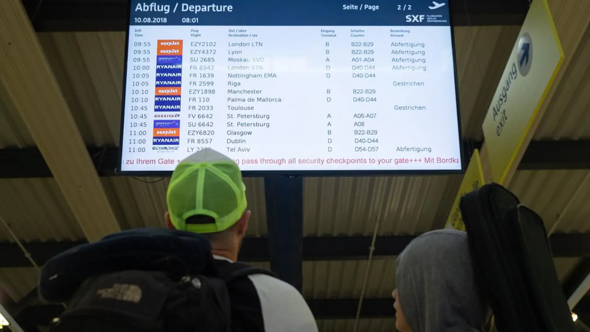 Una pareja observa una pantalla en la que se muestra información sobre los vuelos durante la huelga de 24 horas convocada por los pilotos de Ryanair en el aeropuerto de Berlín (Alemania) / Foto: Efe