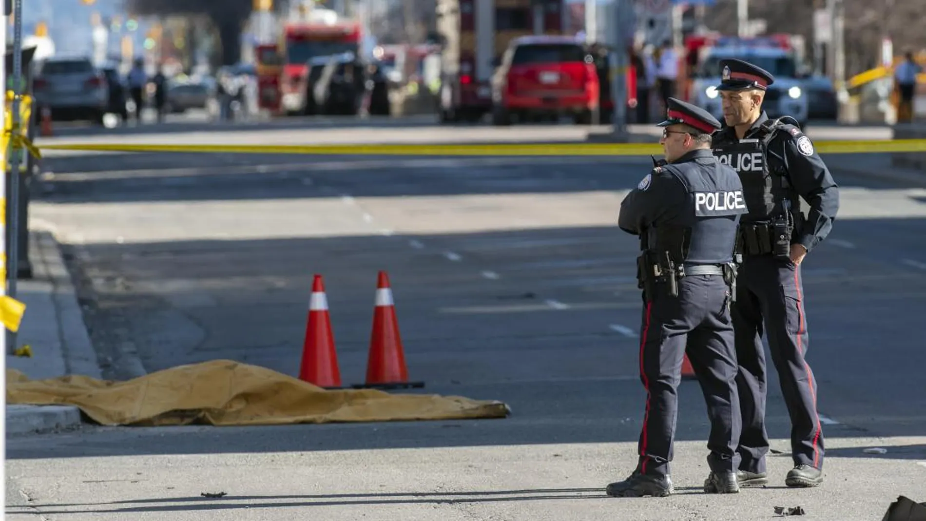 Miembros de la policía de Toronto montan guardia junto a un cuerpo cubierto por una manta