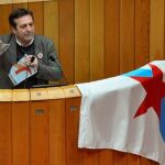 Luís Bará mientras rompe una imagen del Rey en la tribuna durante su intervención en Parlamento de Galicia