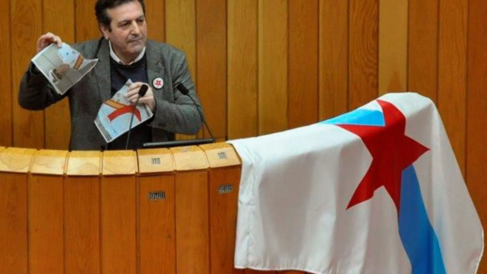 Luís Bará mientras rompe una imagen del Rey en la tribuna durante su intervención en Parlamento de Galicia