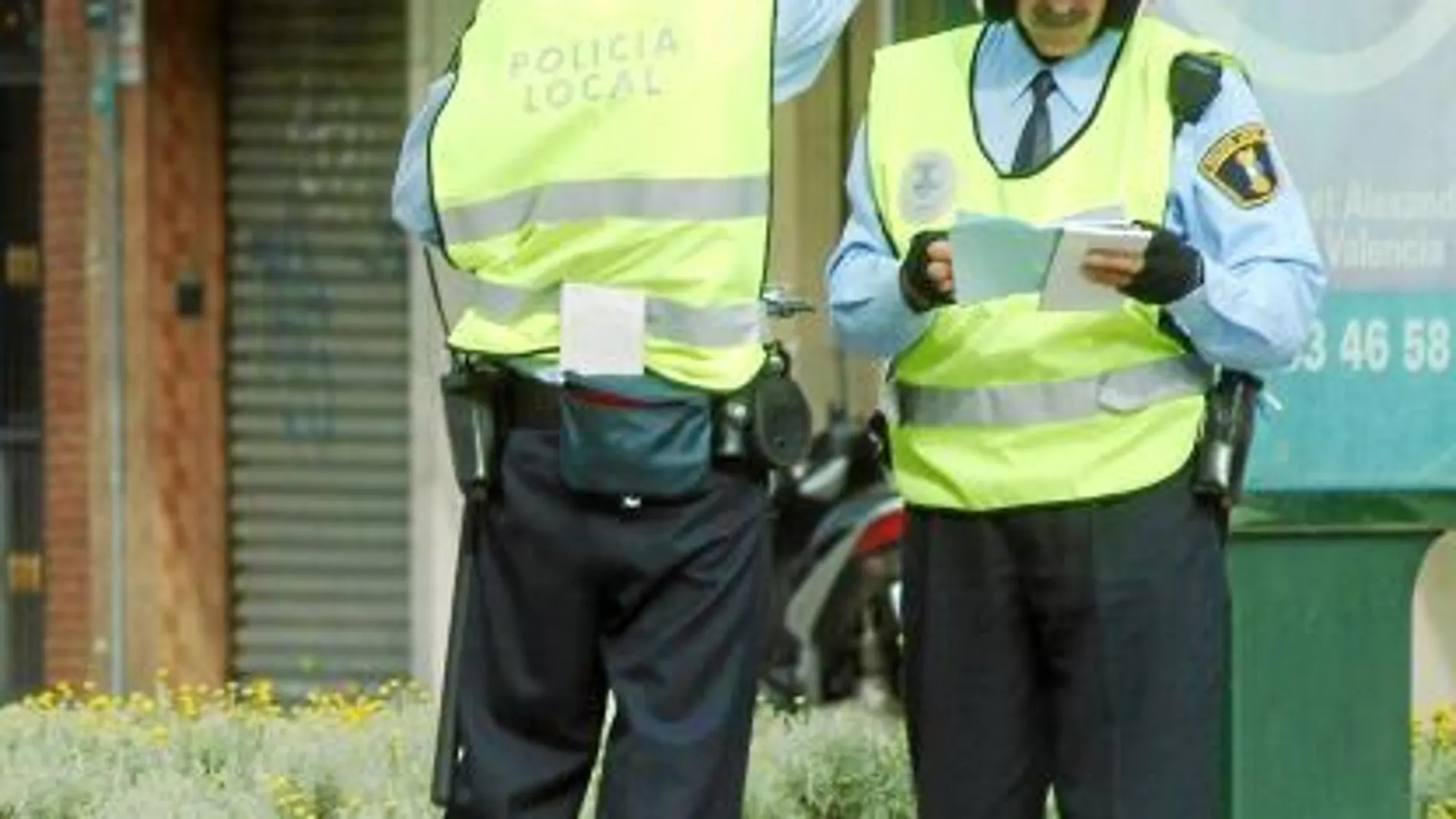 Dos agentes verifican una documentación en una calle de Valencia