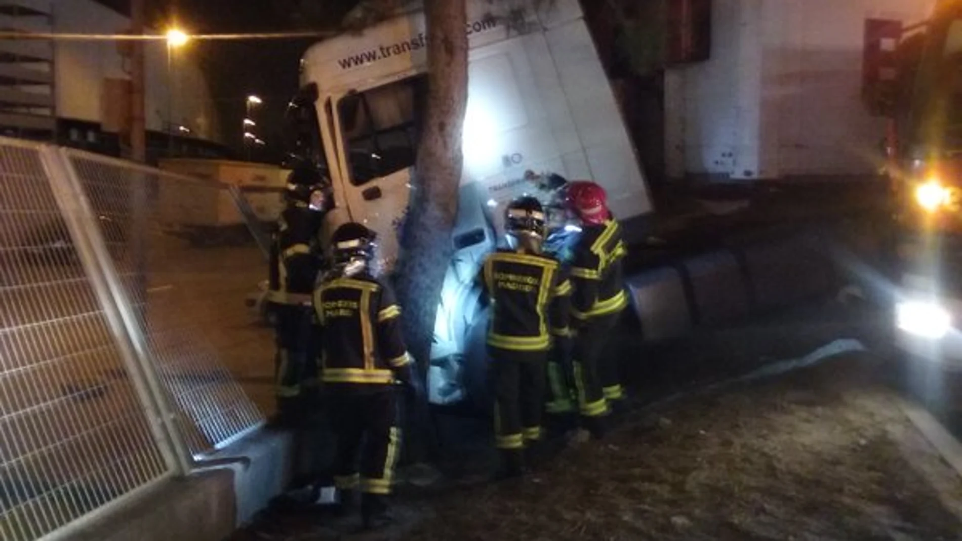 Los bomberos intentan liberarl el cuerpo del camionero atrapado