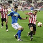 El defensa del Logroñés, Molina (d), protege el balón ante el acoso del delantero del Valencia, Aritz Aduriz, durante el encuentro correspondiente a la ida de los dieciseisavos de final de la Copa del Rey