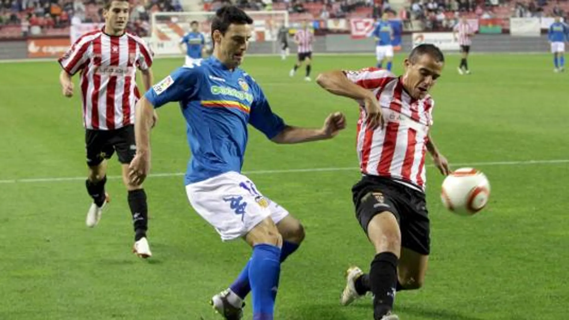 El defensa del Logroñés, Molina (d), protege el balón ante el acoso del delantero del Valencia, Aritz Aduriz, durante el encuentro correspondiente a la ida de los dieciseisavos de final de la Copa del Rey