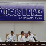El presidente de Colombia Juan Manuel Santos (i) y el máximo líder de las FARC, Rodrigo Londoño (d), alias "Timochenko", realizan una declaración conjunta acompañados por el presidente de Cuba Raúl Castro.