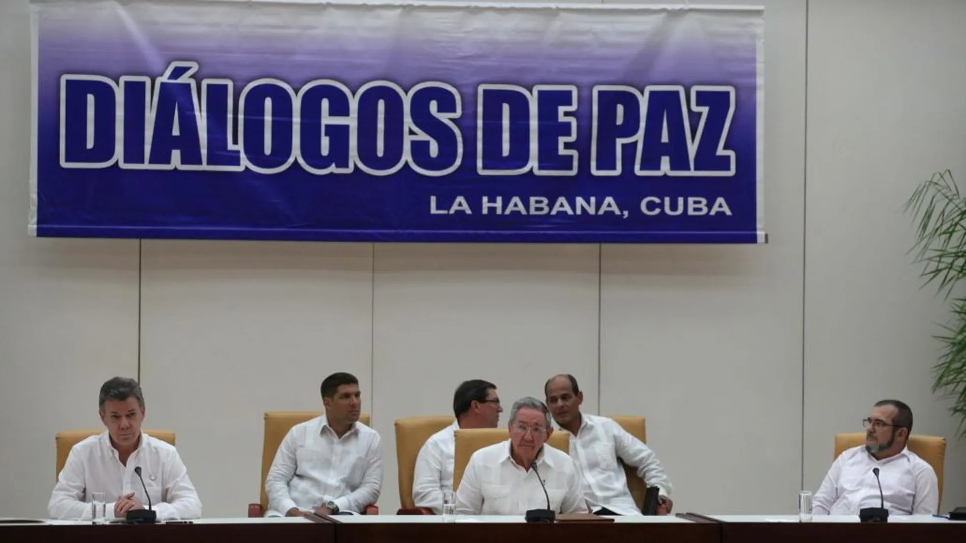 El presidente de Colombia Juan Manuel Santos (i) y el máximo líder de las FARC, Rodrigo Londoño (d), alias "Timochenko", realizan una declaración conjunta acompañados por el presidente de Cuba Raúl Castro.