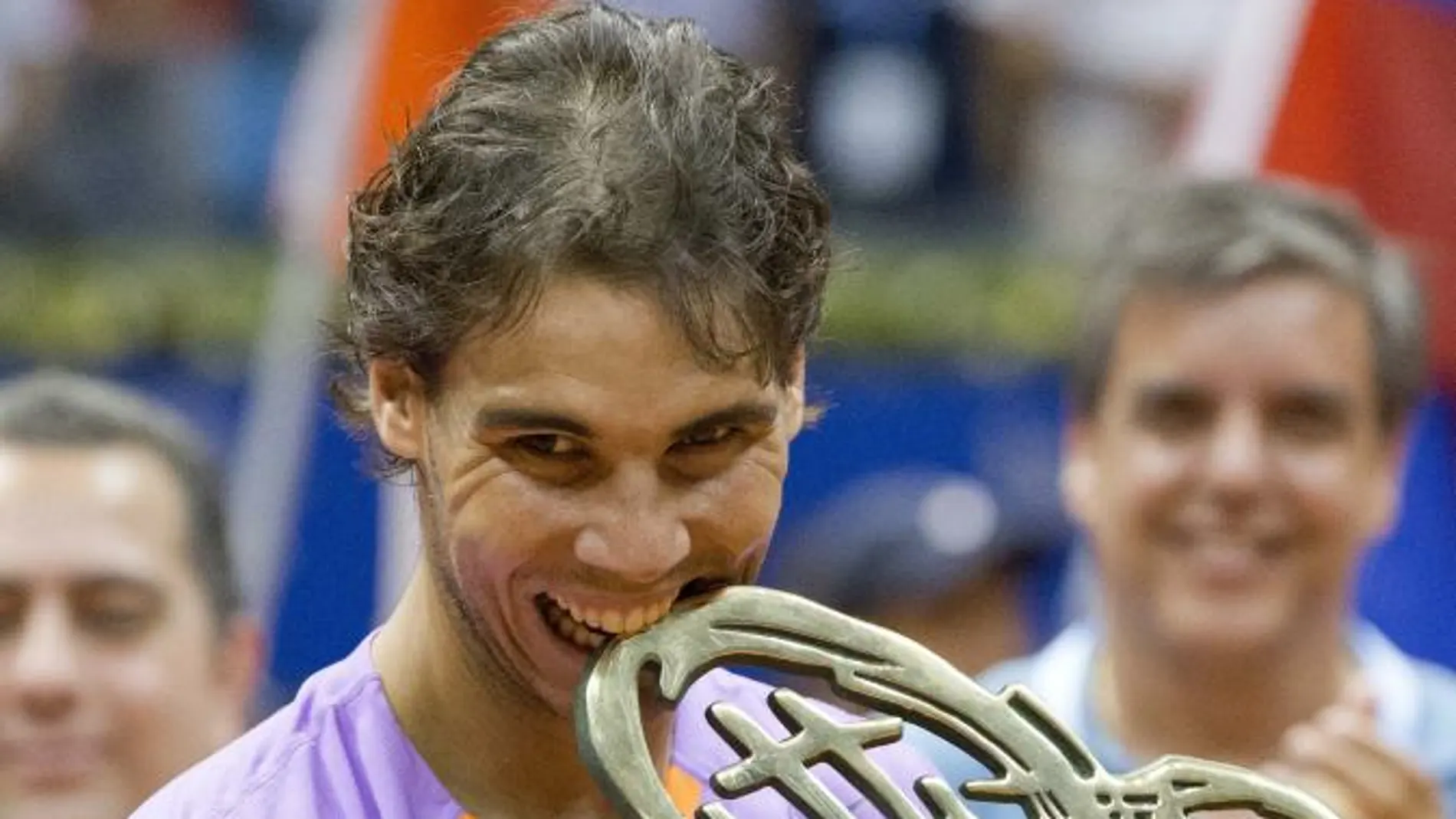 El tenista español Rafael Nadal posa mordiendo el trofeo de campeón del Abierto de Tenis de Brasil