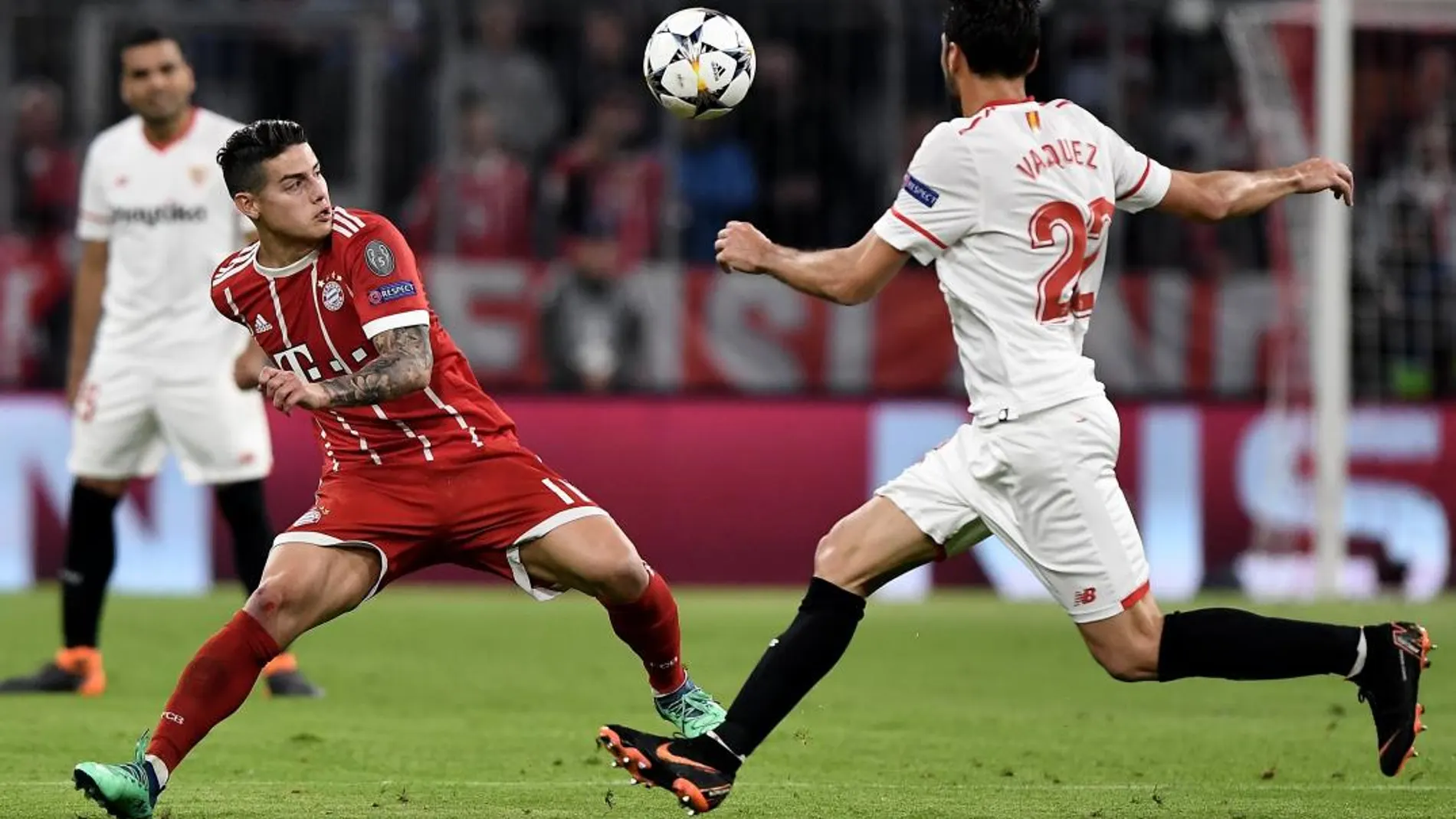 El jugador James Rodríguez de Bayern disputa el balón con Franco Vázquez de Sevilla