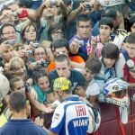 Valentino Rossi firma autógrafos a una multitud de aficionados en el «pit lane» del circuito de Motorland, en Alcañiz
