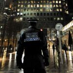 Un guardia de seguridad patrulla en el distrito financiero Canary Wharf en Londres