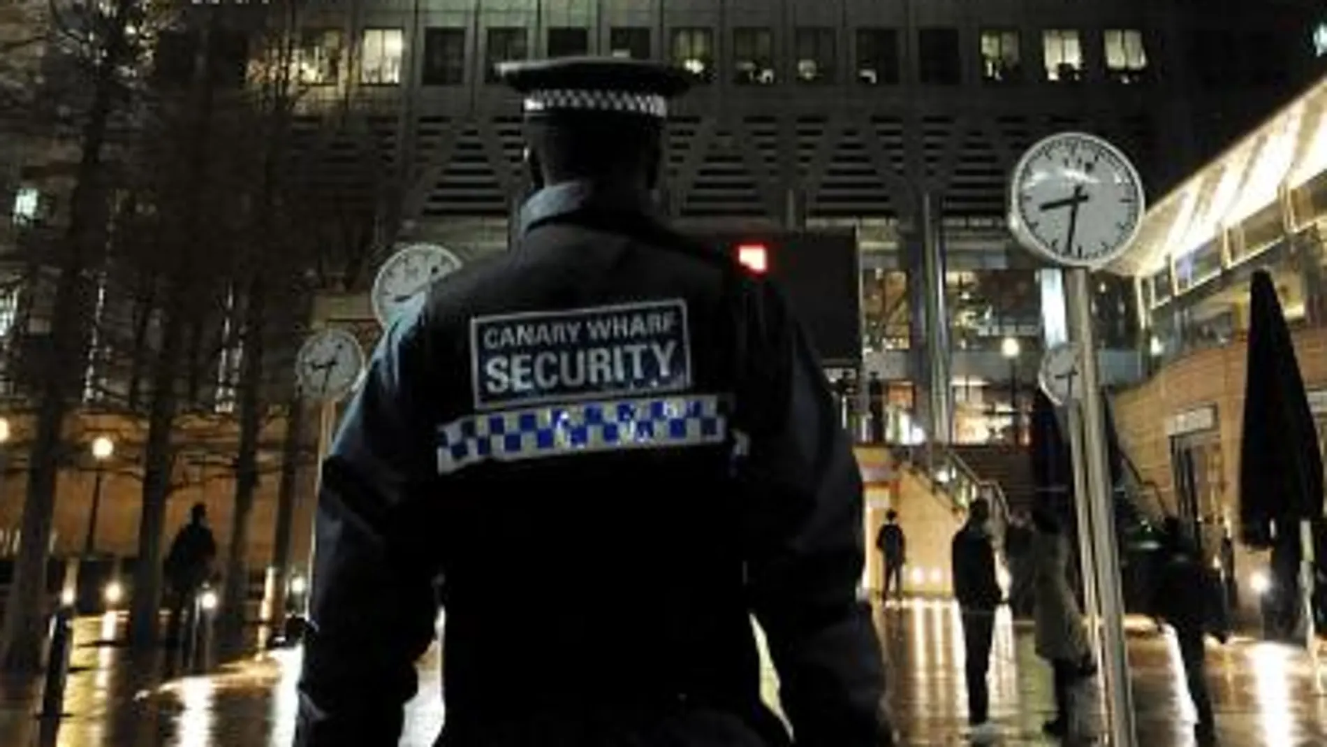 Un guardia de seguridad patrulla en el distrito financiero Canary Wharf en Londres