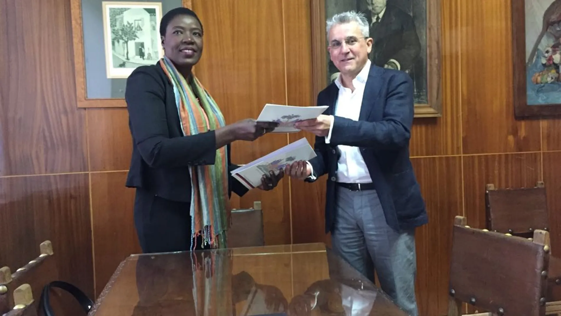 Olga Médor Ducasse, encargada de Negocios de la Embajada de Haití en España y el director de la Escuela de Arte de Granada, Blas Calero Ramos, intercambiando el acuerdo firmado entre ambos países.