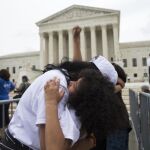Dos familiares inmigrantes se abrazan durante la concentración de espera de la decisión ante la Corte del Tribunal Supremo en Washington