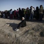 Refugiados hacen fila para recibir provisiones en un campo de refugiados en Idomeni cerca la frontera de Grecia con Macedonia (Grecia)
