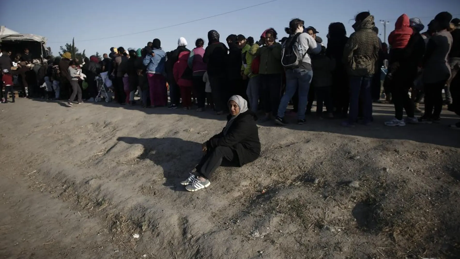 Refugiados hacen fila para recibir provisiones en un campo de refugiados en Idomeni cerca la frontera de Grecia con Macedonia (Grecia)