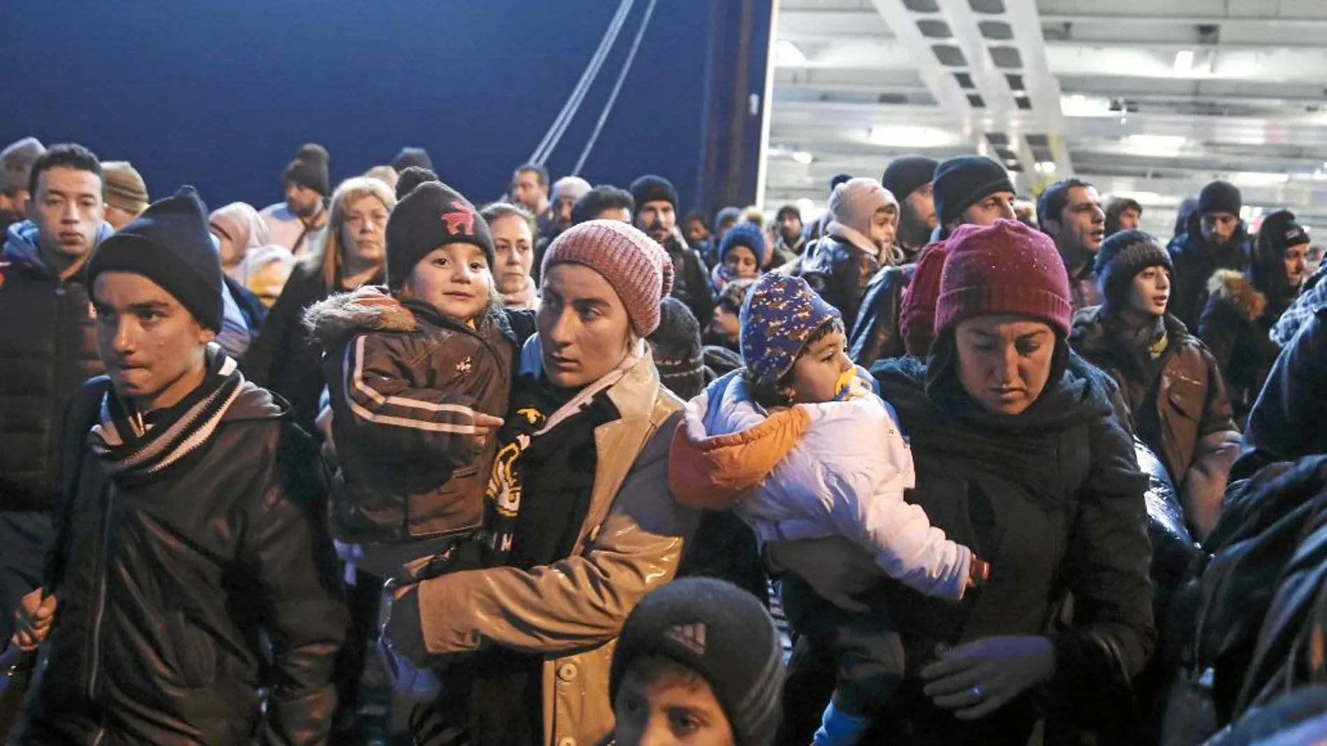 Varios refugiados llegan a bordo del ferry Nissos Rodos al puerto ateniense del Pireo, en Grecia, para continuar su ruta hacia el interior de Europa.
