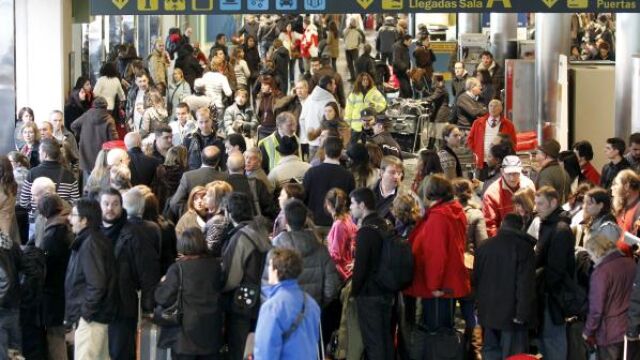 Centenares de personas esperan información de sus vuelos, en el aeropuerto de Lvacolla, donde se han cancelado varios vuelos y desviado otros a causa del conflicto de los controladores aéreos, esta mañana en Santiago de Compostela