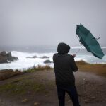 Un hombre ve como el viento le dobla el paraguas en A Coruña
