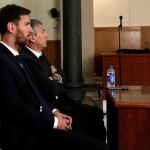 El jugador del FC Barcelona Lionel Messi y su padre, Jorge Horacio Messi (detrás), en la sala de la Audiencia de Barcelona