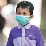 Un preescolar se protegía ayer de la gripe en Malasia