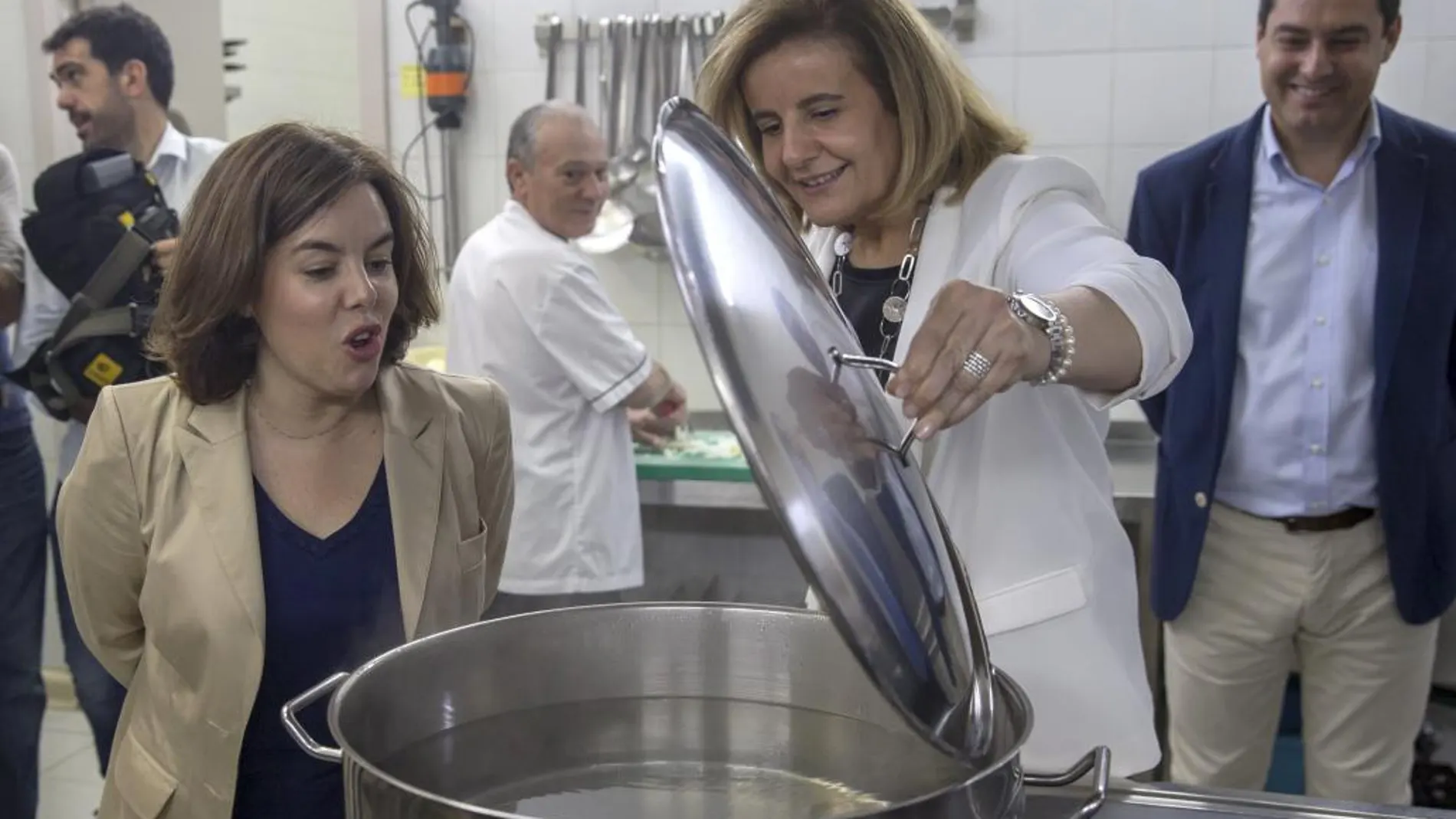 Fátima Báñez, junto a Juanma Moreno y Soraya Sáenz de Santamaría en un Centro de Acogida a Refugiados de Sevilla esta semana.