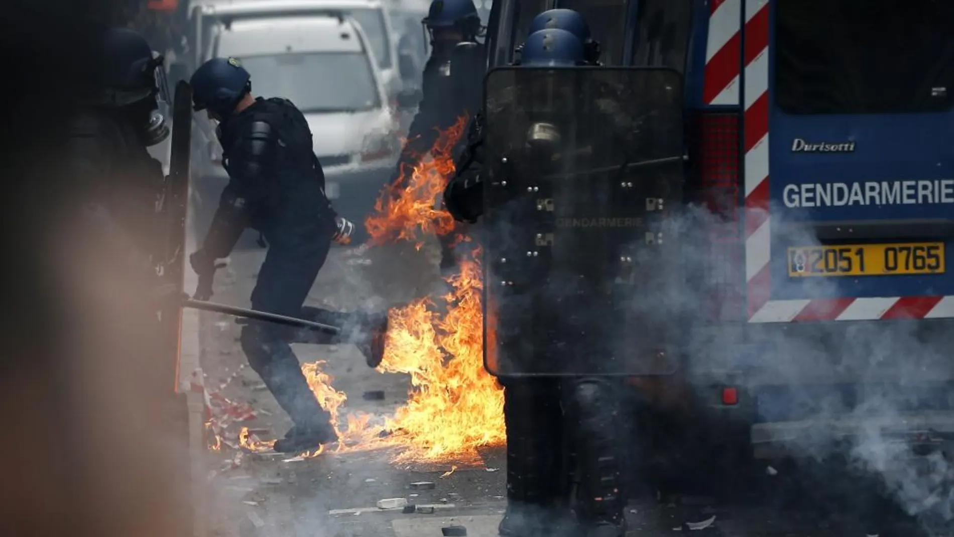 Varios policías huyen tras el lanzamiento de un cóctel mólotov durante la manifestación contra la reforma laboral del Gobierno en París, Francia