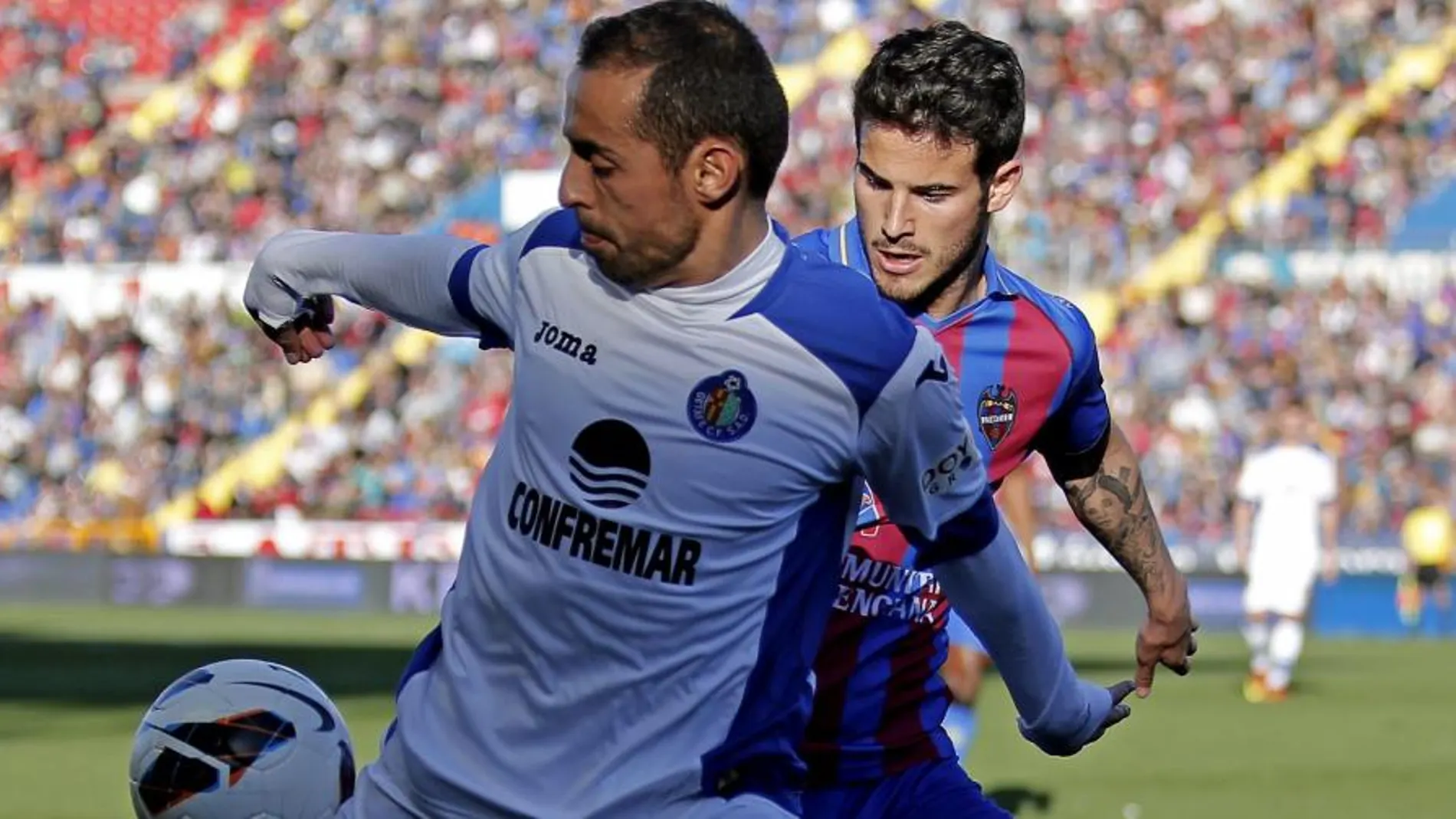 El jugador del Getafe CF, Diego Castro,iz disputa un balón al jugador del Levante UD, Rubén García