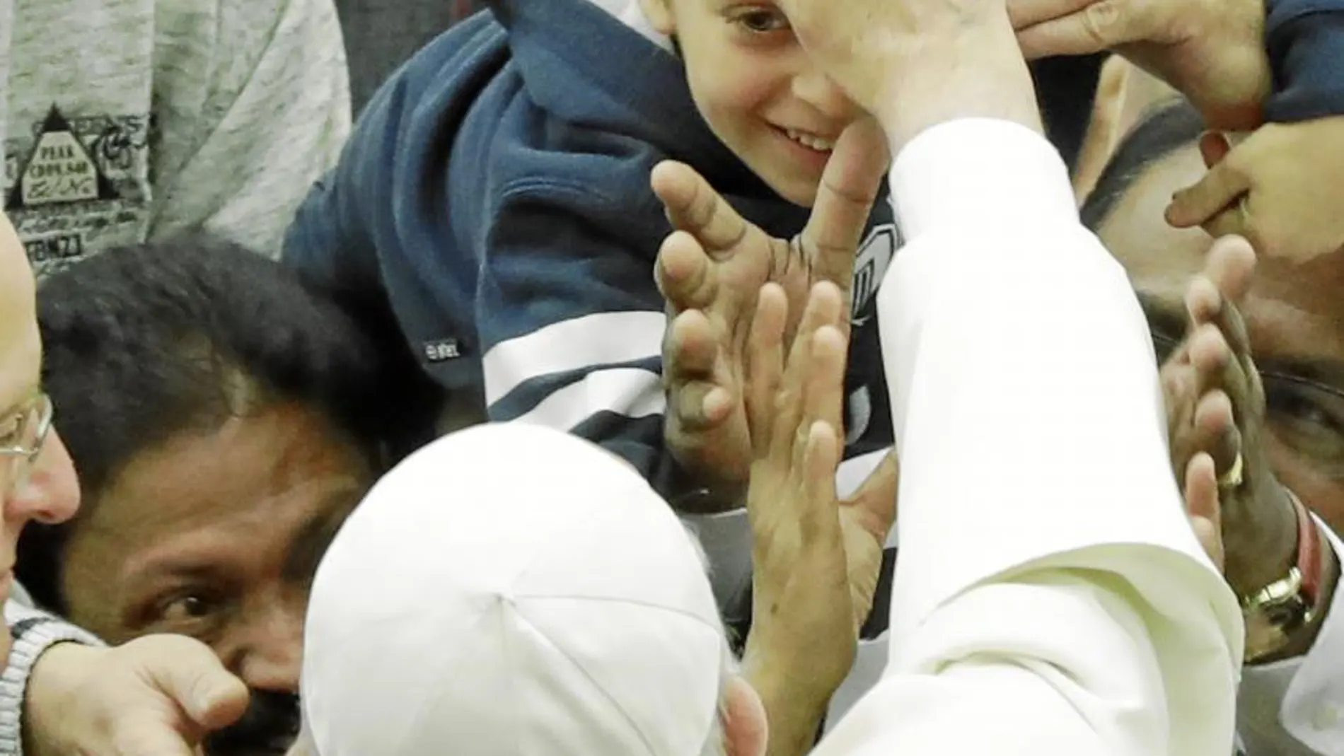 Francisco bendice a un niño, a su llegada a la audiencia general prevista en el aula Pablo IV